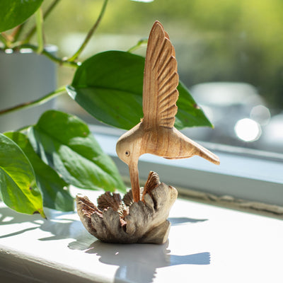 Sculptură realizată manual cu un colibri care bea nectar dintr-o excrescență lemnoasă