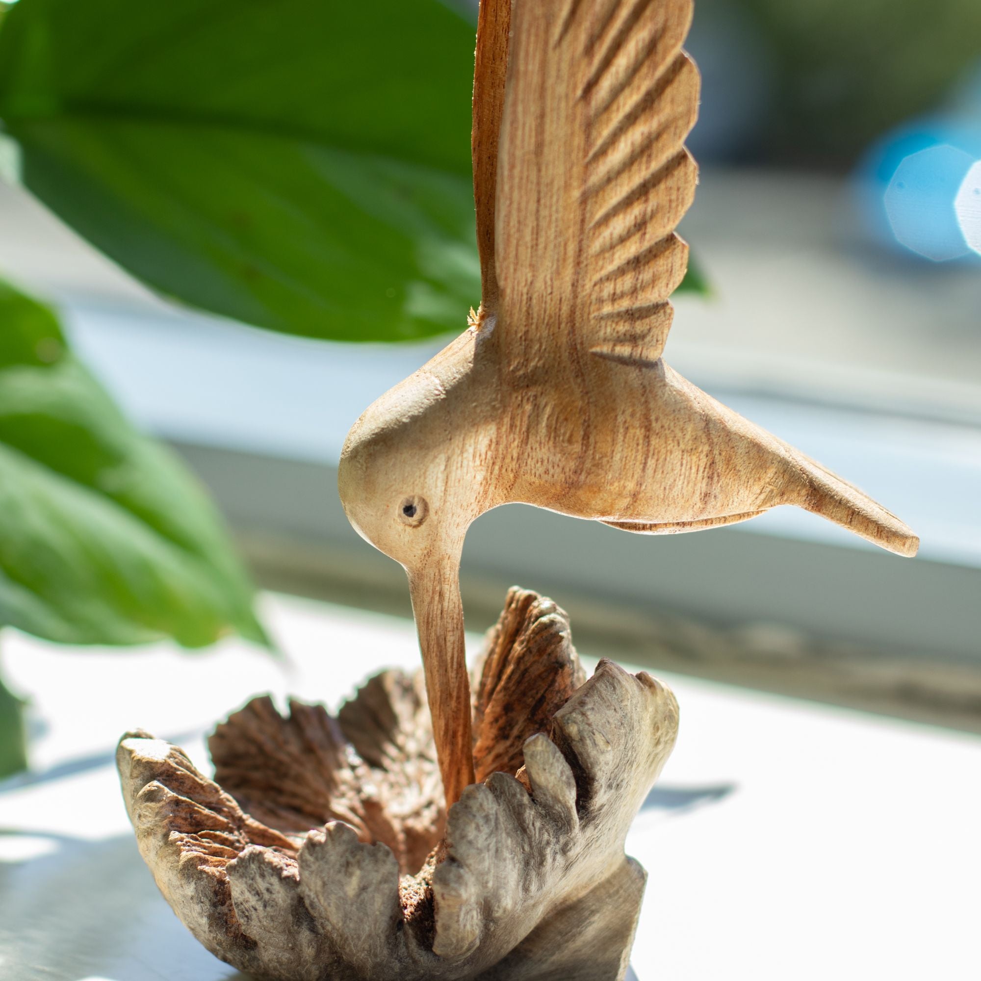 Sculptură realizată manual cu un colibri care bea nectar dintr-o excrescență lemnoasă